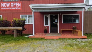 A red building with a sign stating "The Hibernation Station" and "NOW OPEN UNDER NEW OWNERSHIP". - The Hibernation Station (Sterling)