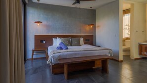 A modern bedroom with a wooden bed, a ceiling fan, and two pendant lights.
