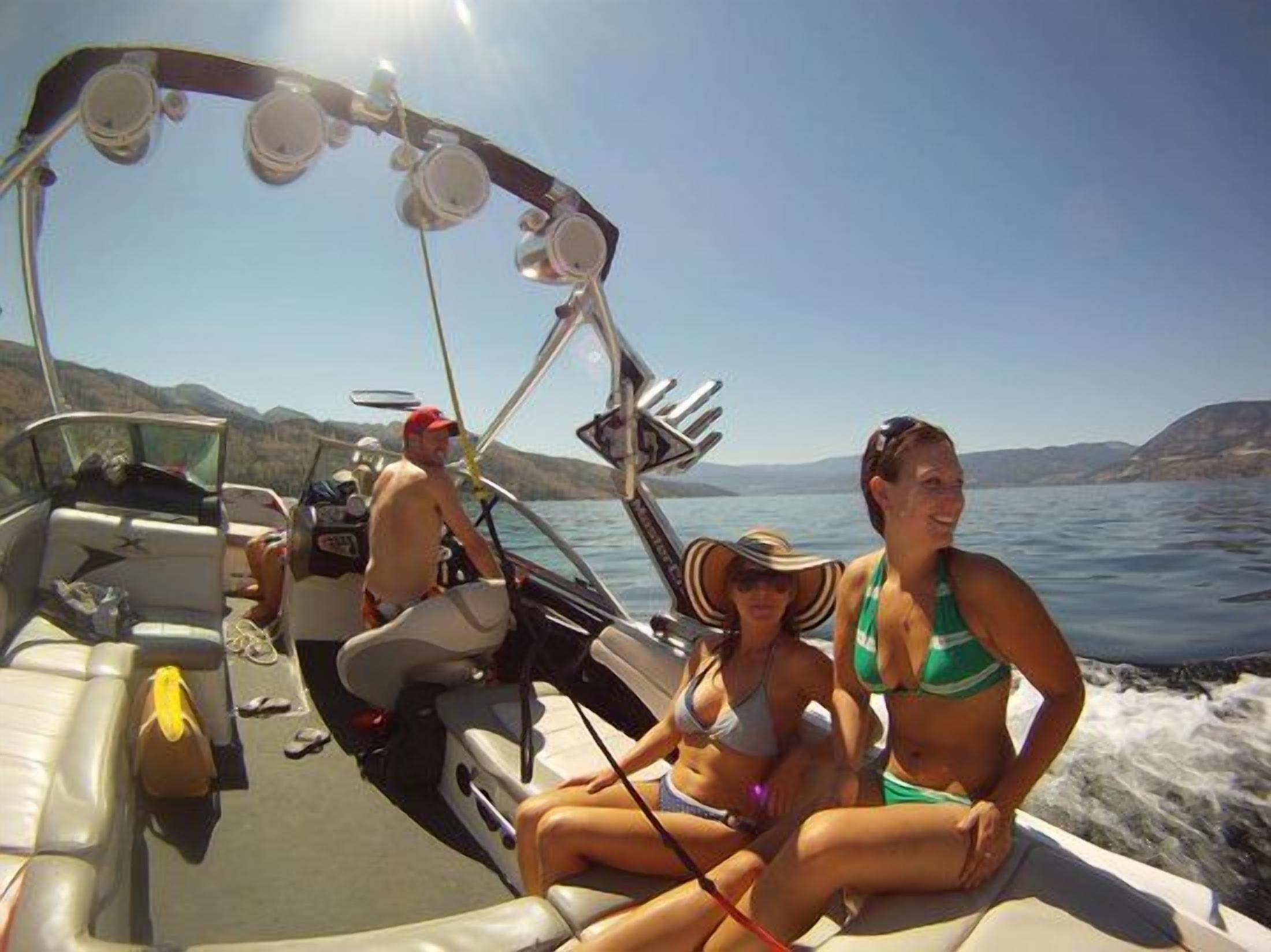 A boat with a seating area, a steering wheel, and a person in a hat.