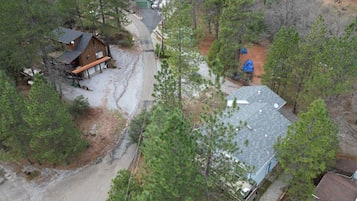A residential area with multiple houses, a driveway, and surrounding trees.
