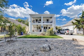 A two-story building with a balcony, a gravel driveway, and a parked truck. - Travel Nurse Landing in Delano! W&D In Unit (Wichita)