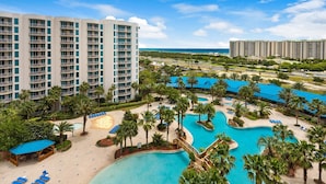 A resort with multiple swimming pools, palm trees, and beachfront views. - Palms Resort #1813 Jr. 2BR (Destin)
