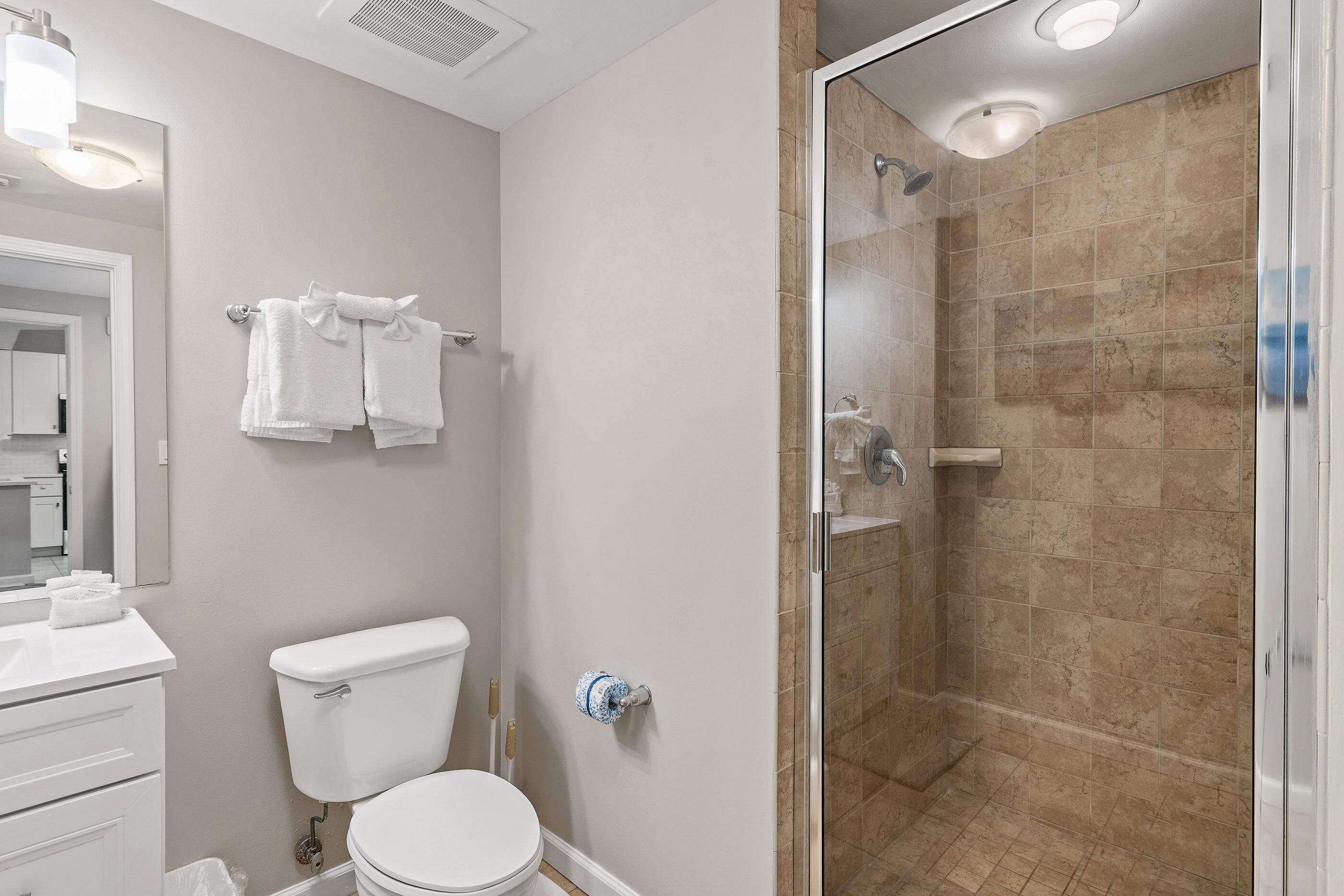A bathroom with a toilet, sink, and shower.