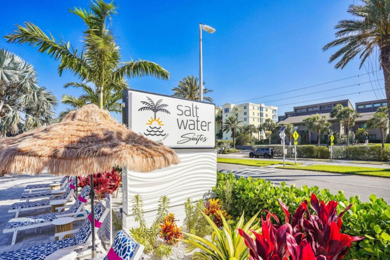 A sign for 'Salt Water Suites' with a beach theme, including a palm tree and sun icon.