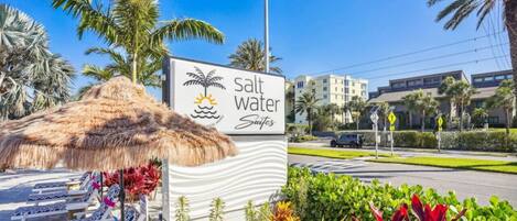 A sign for 'Salt Water Suites' with a beach theme, including a palm tree and sun icon.
