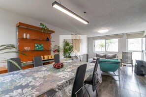 Relax in this inviting space with a large dining table, comfortable seating area, and plenty of natural light.