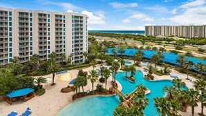 A resort with multiple swimming pools, palm trees, and beachfront views. - Palms Resort #1202 Full 2 Bedroom (Destin)
