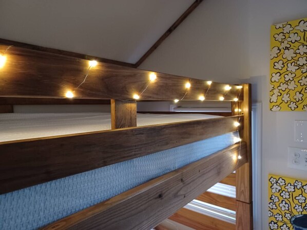 Cozy retreat with a bunk bed, sloped ceiling, and warm lighting.