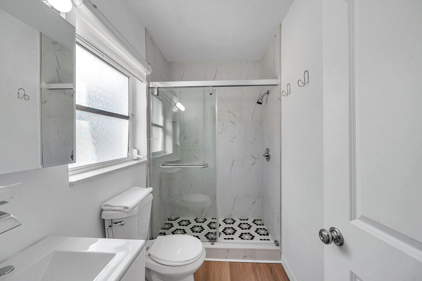 A bathroom with a toilet, sink, and shower.