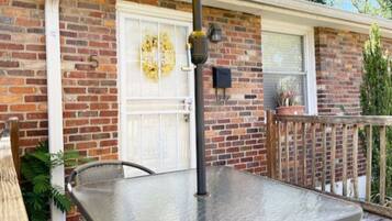A brick house with a white garage door, a metal table, and a potted plant.