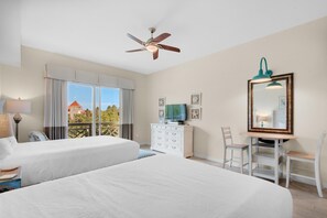 A hotel room with two beds, a ceiling fan, a TV on a dresser, a desk with a chair, and a large mirror. - Bahia 4417- The Bahia Beach House (Miramar Beach)