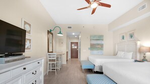 A hotel room with a TV, a desk, two beds, a ceiling fan, and artwork on the walls. - Bahia 4417- The Bahia Beach House (Miramar Beach)