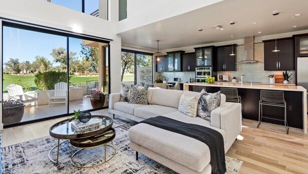 Ein moderner, offener Wohnbereich mit Sofa, Couchtisch und Blick ins Freie.