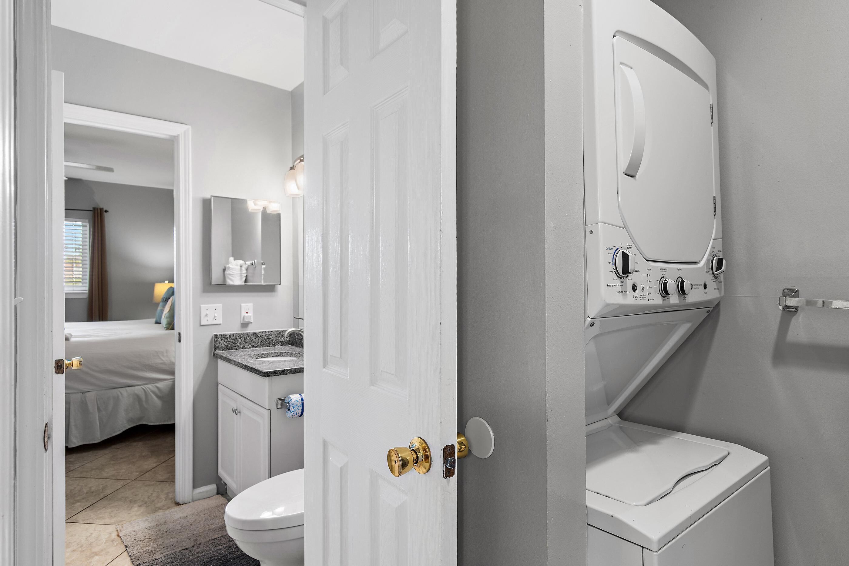 Ein Badezimmer mit Toilette, Waschbecken, Spiegel und Waschmaschine.