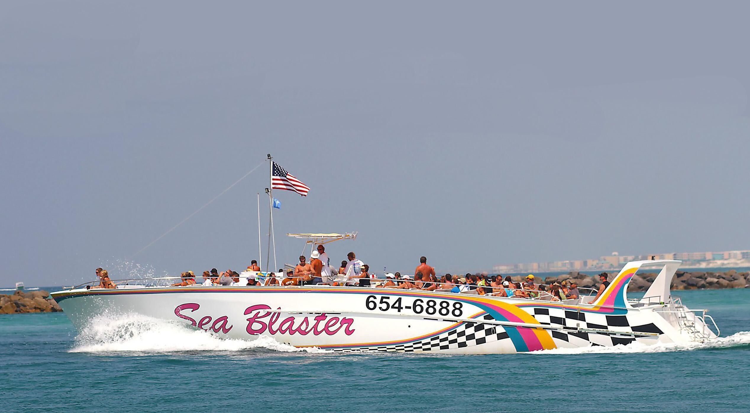 A speedboat named 'Sea Blaster' with the number 654-6888, featuring a colorful checkered pattern and an American flag.