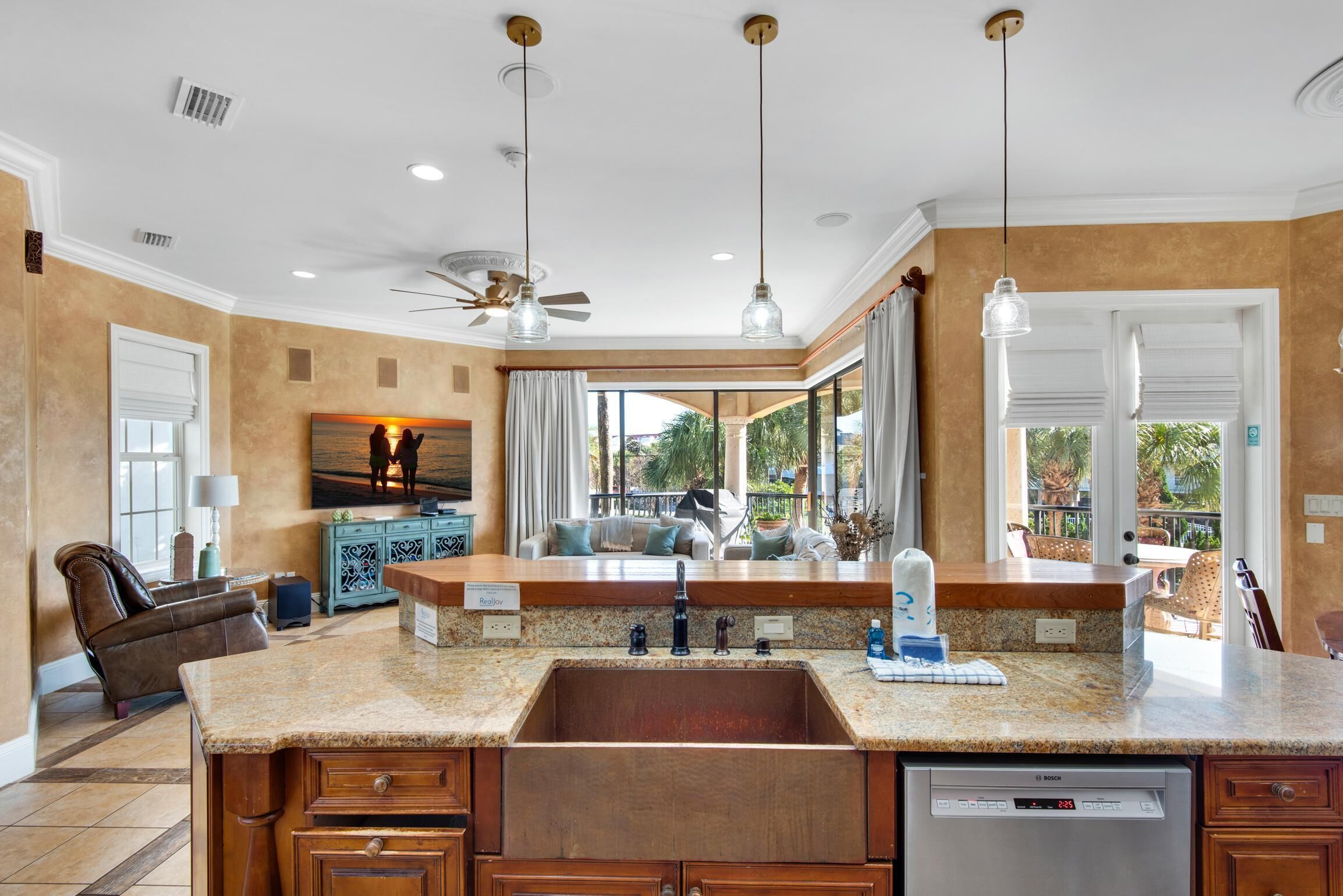 A spacious kitchen with granite countertops, a Bosch dishwasher, and a large island with a sink.