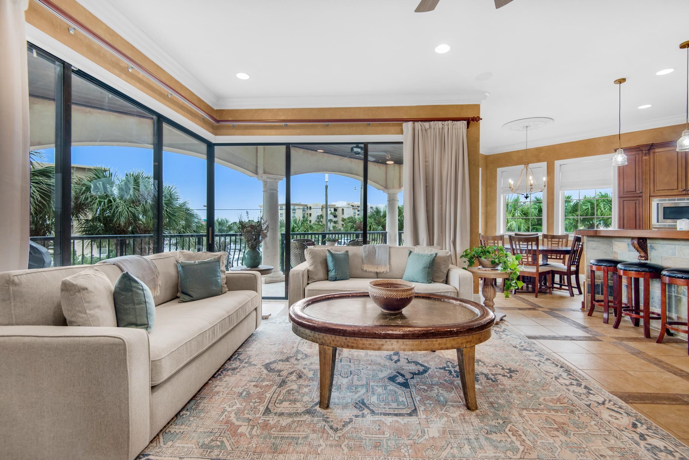 A spacious living area with a large sofa, a coffee table, and a dining set.
