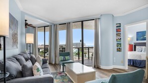A modern hotel room with a balcony, a sofa, a coffee table, and a bed. - Surfside Resort #309 (Miramar Beach)