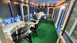 A cozy indoor seating area with tables and chairs, a fan, and string lights. - Marina’s Cozy Cottage. Family friendly with cold AC in summer and warm winters! (Rio Hondo)