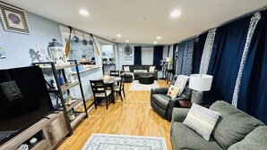 A modern living room with a TV, sofa, and dining area. - Marina’s Cozy Cottage. Family friendly with cold AC in summer and warm winters! (Rio Hondo)