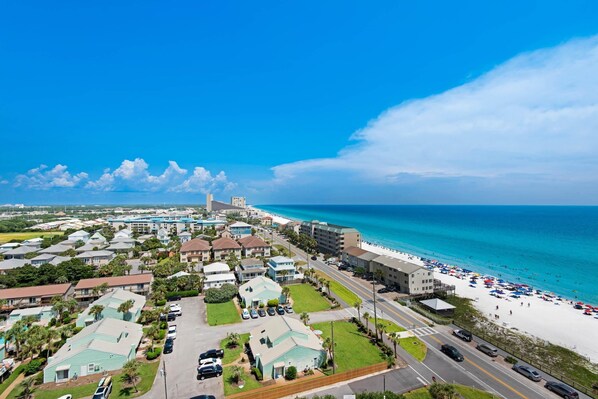 A coastal resort area with beachfront properties, a road leading to the beach, and a clear view of the ocean.