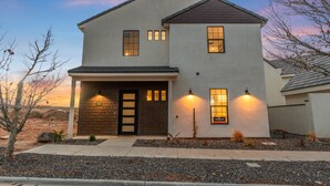 Ein zweistöckiges Haus mit Garage, steinernen Eingang und angelegtem Vorgarten.