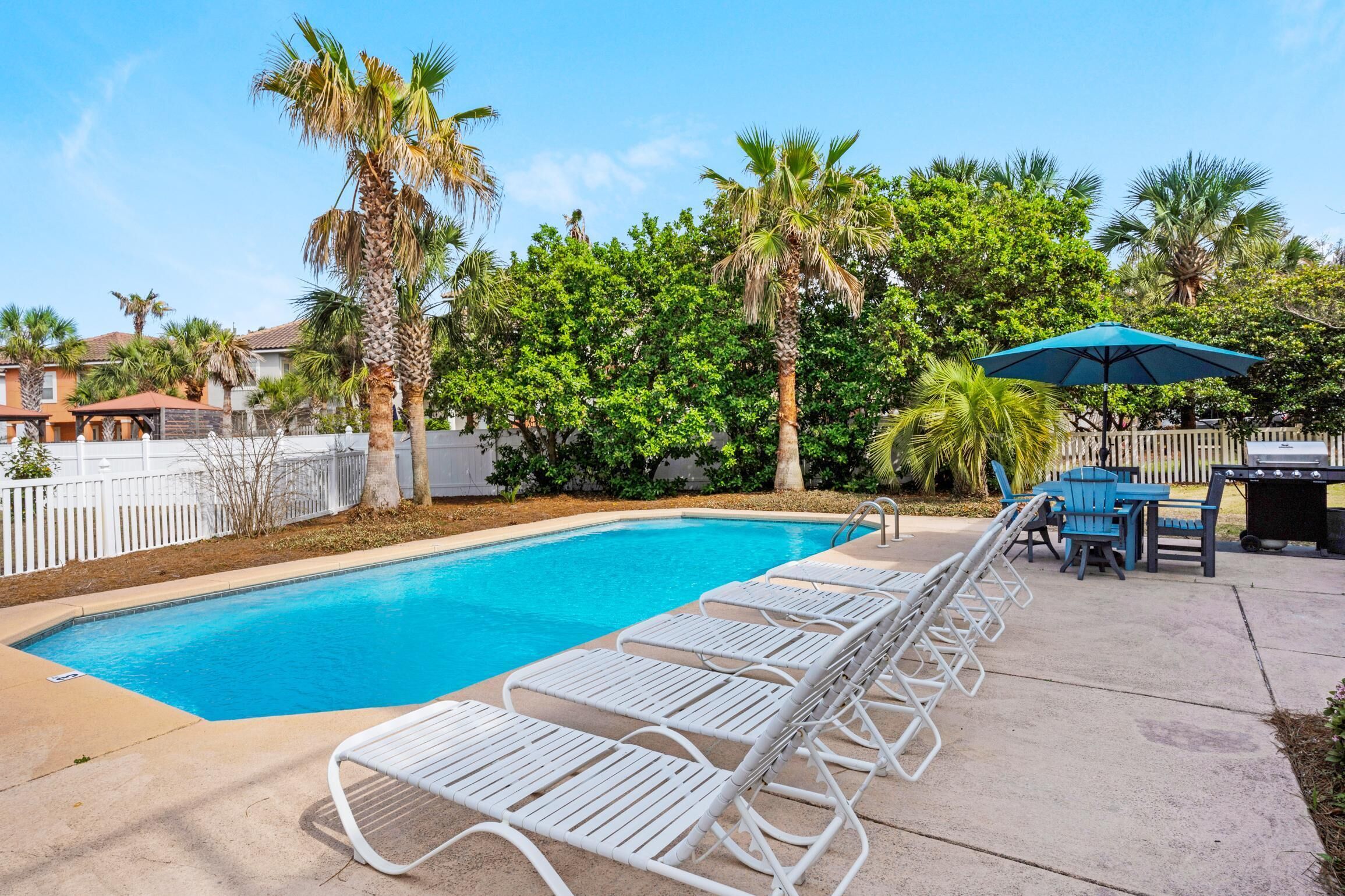Piscina con sillones de descanso y zona de barbacoa.