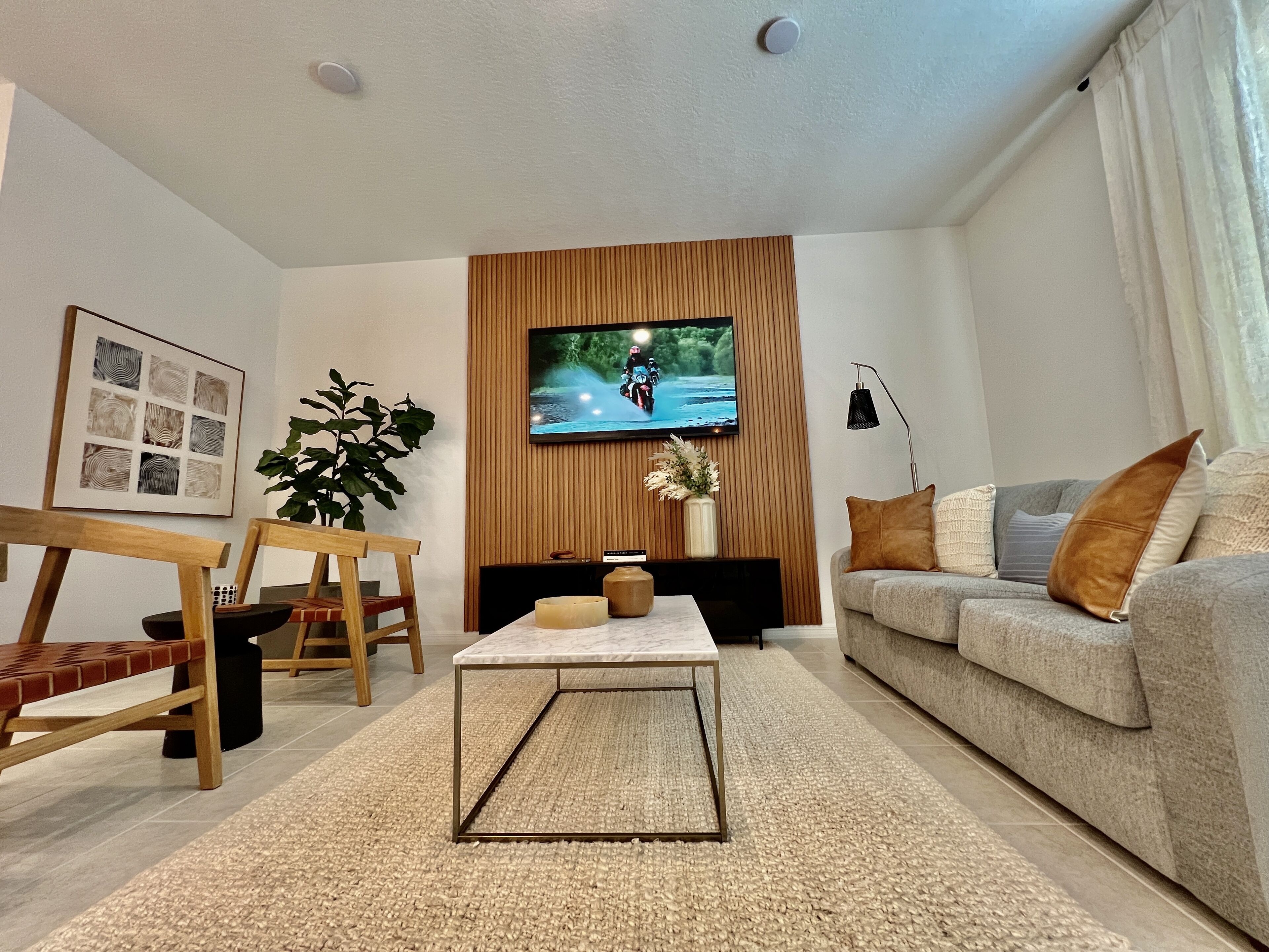 A modern living room with a TV, sofa, coffee table, and wooden furniture.