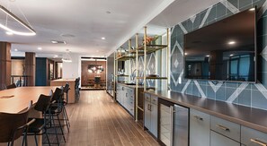 A modern kitchen with a long counter, built-in appliances, and a dining area with a round table and chairs.