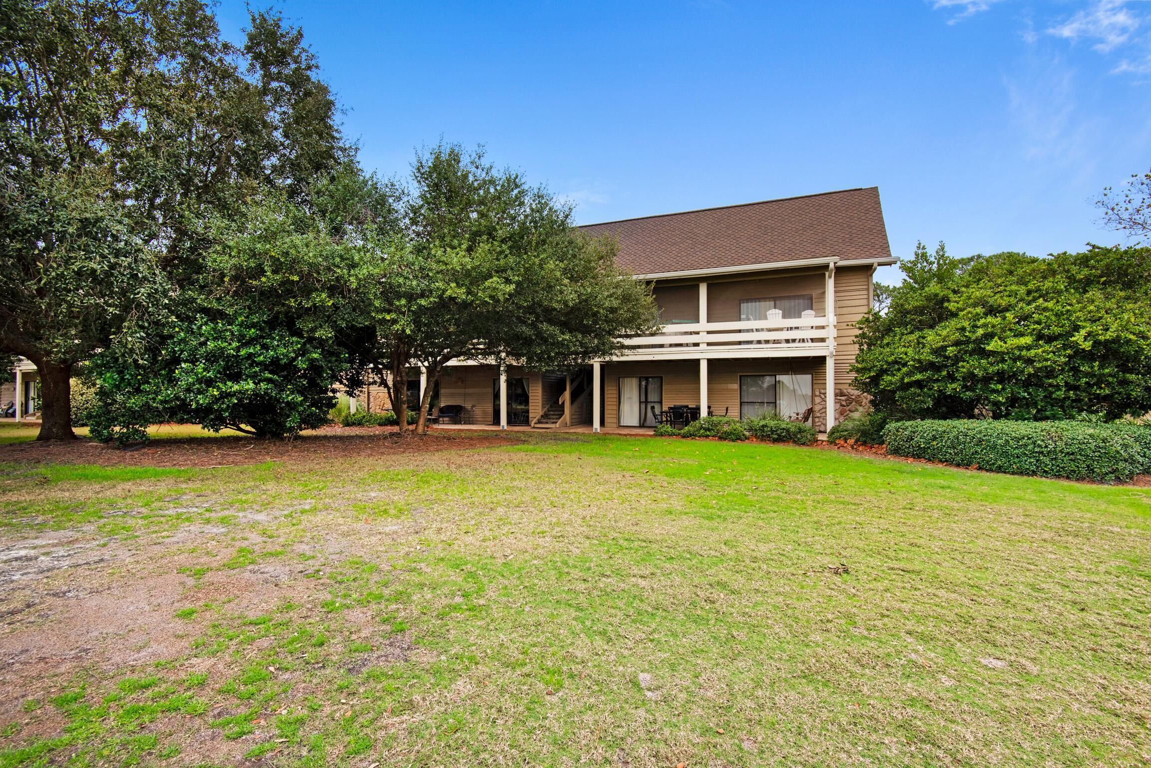 A two-story building with a covered porch and a well-maintained lawn.