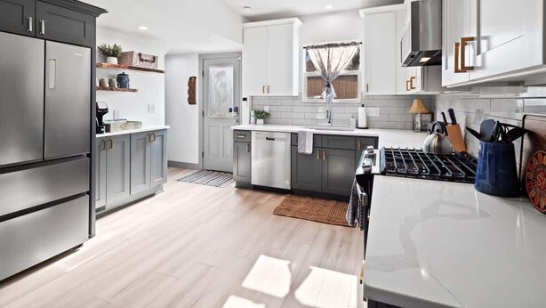 Una cocina moderna con gabinetes grises, electrodomésticos de acero inoxidable y una isla central.
