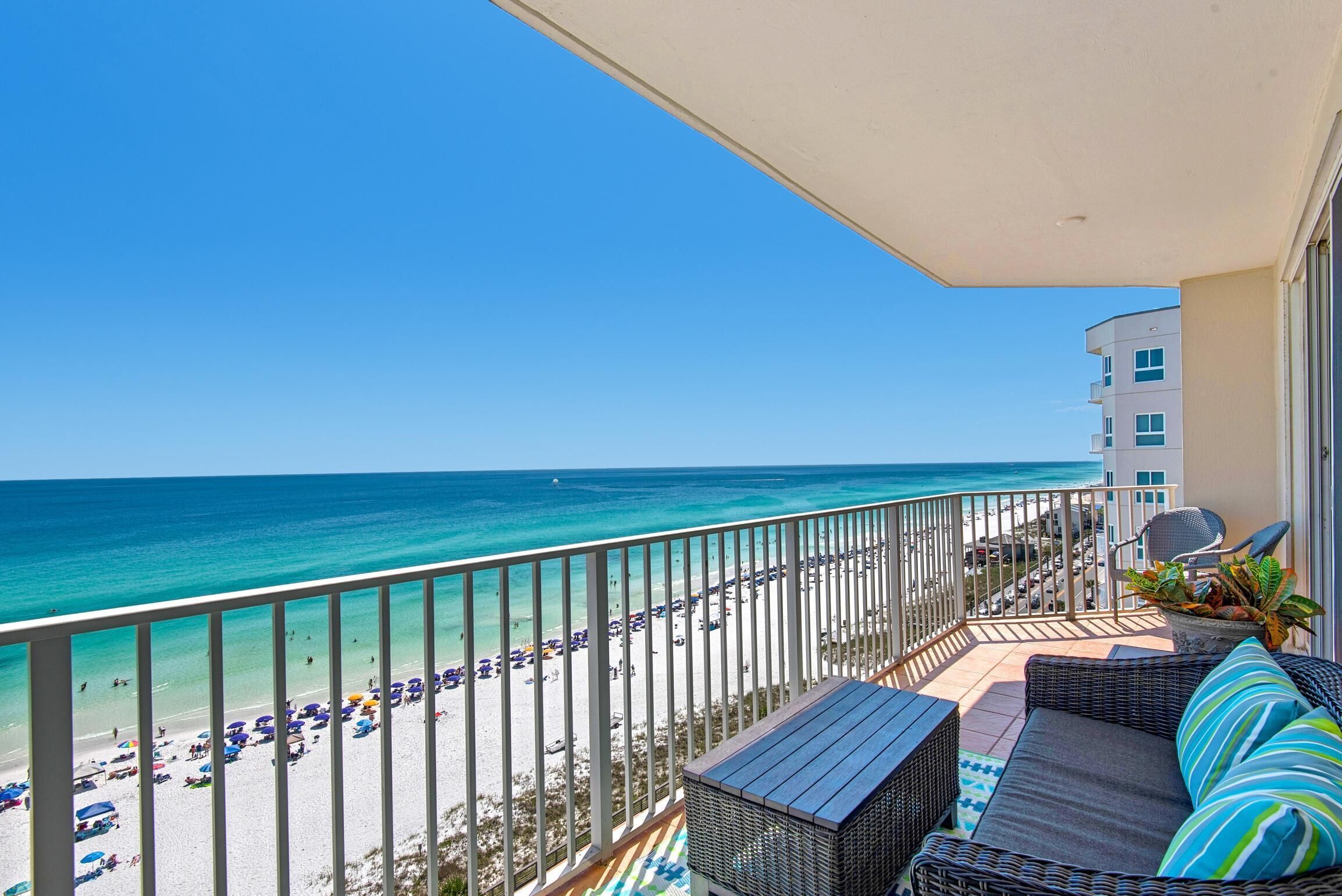 A balcony with a view of the beach and ocean.