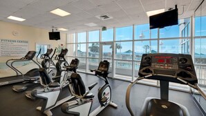 A fitness center with treadmills, ellipticals, and a TV mounted on the wall. - Majestic Sun 1012a (Miramar Beach)