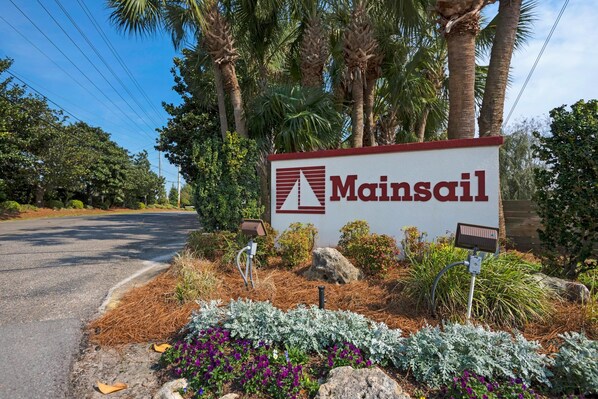 A sign for Mainsail with a solar-powered street light and landscaped garden.