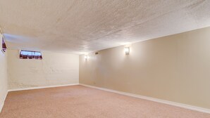 Ein Zimmer mit beige gefärbten Wänden, einer strukturierten Decke und einem Teppichboden.