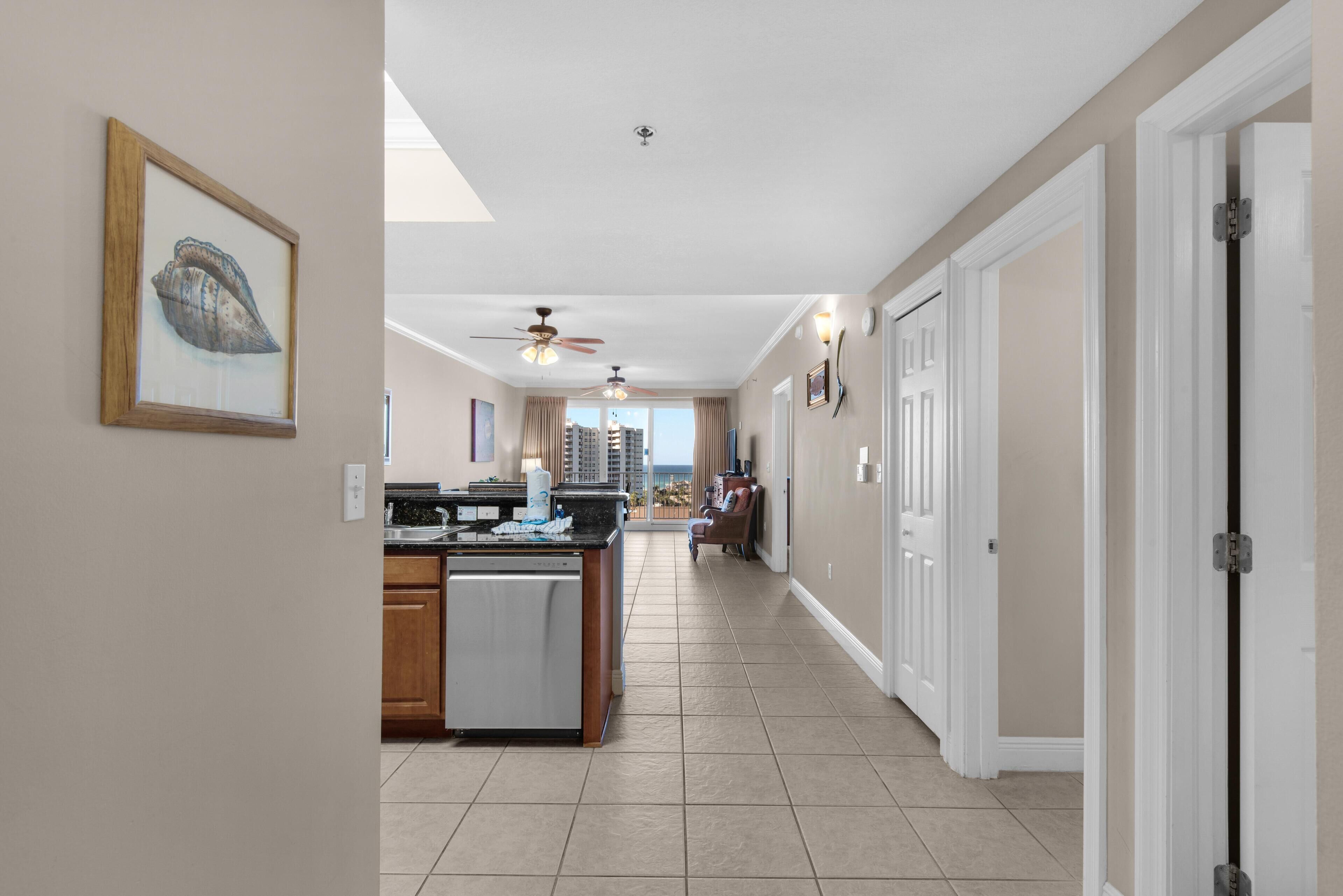 A spacious kitchen with a central island, a dining area with a view, and a hallway leading to a door.