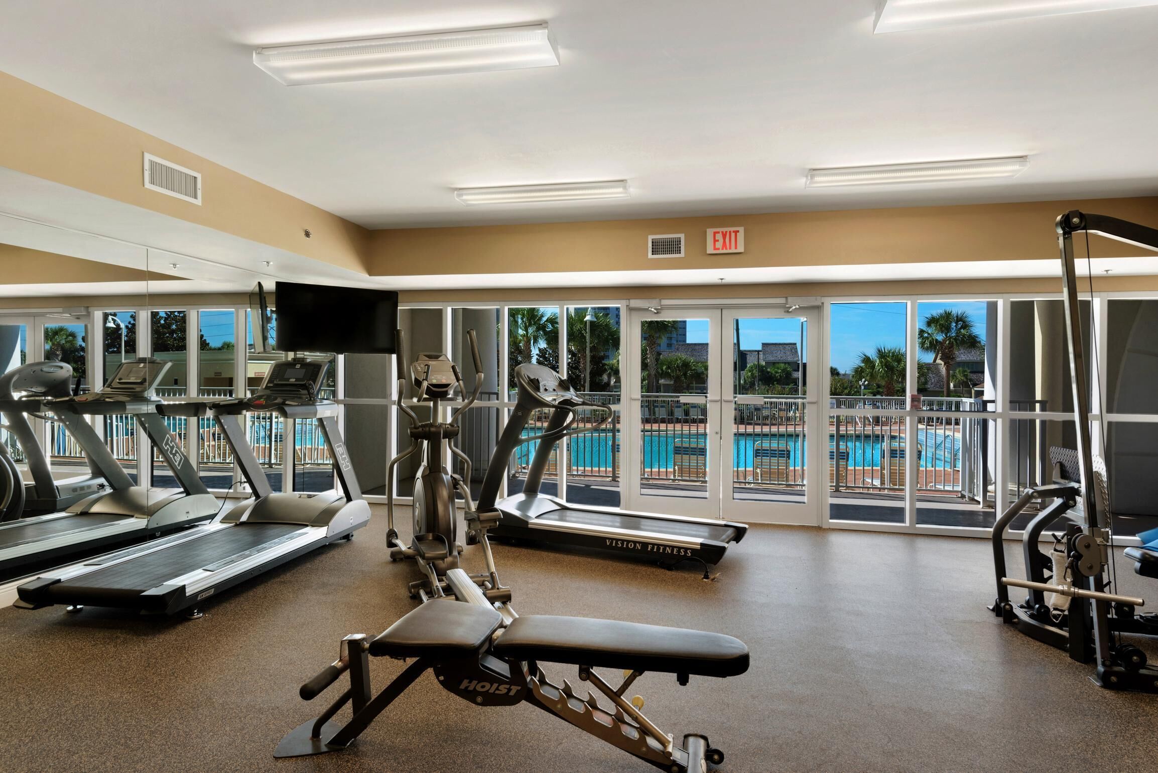 A gym with treadmills, a stationary bike, and a weight bench.