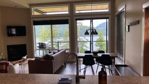 Eine moderne Küche mit einer großen Kochinsel, ein Essbereich mit Aussicht und ein Wohnzimmer mit Kamin.
