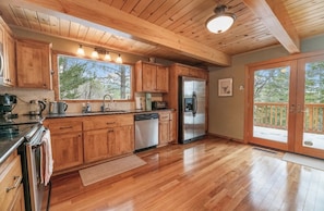 A kitchen with wooden cabinets, stainless steel appliances, and a large window.