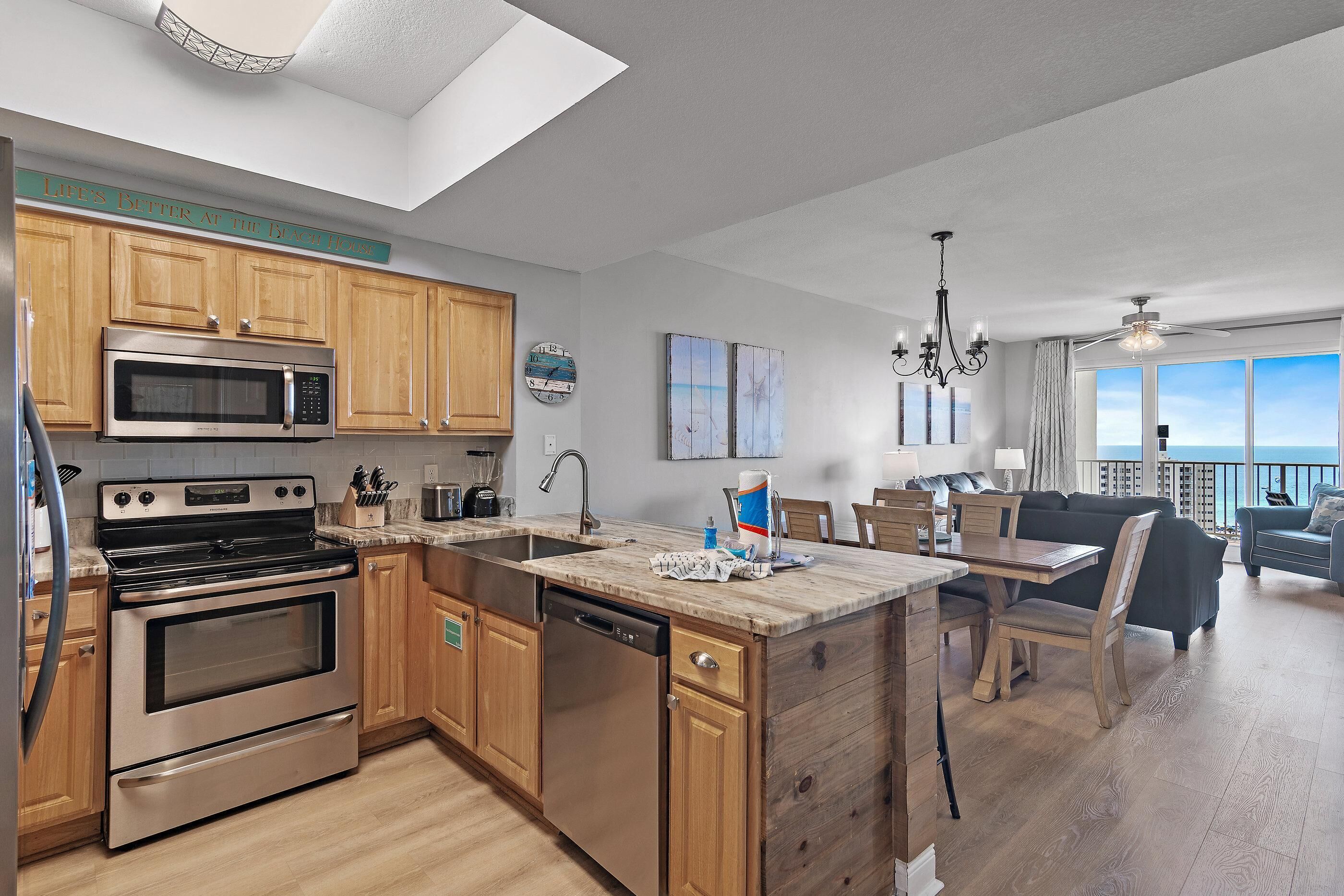 A modern kitchen with wooden cabinets, stainless steel appliances, and a large island with a sink.