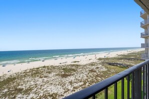 A beach view from a balcony with a clear sky, sandy beach, and a boardwalk. - Shipwatch D604 (Pensacola)