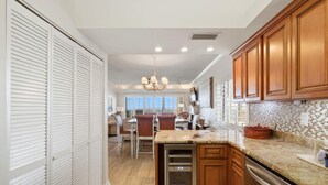 A kitchen with wooden cabinets, a stainless steel refrigerator, and a tiled backsplash. - Shipwatch D604 (Pensacola)
