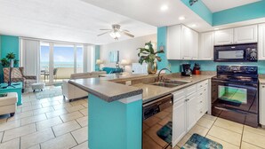 A modern kitchen with white cabinets, a stainless steel oven, and a dishwasher. - Perdido Sun 612 (Pensacola)