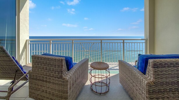 A balcony with wicker furniture and a view of the ocean. - Indigo West 1802 (Pensacola)