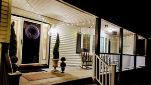 A porch with a wooden railing, a rocking chair, and a wreath on the door. - Quiet & cozy home, bring the whole family. (Monroe Township)