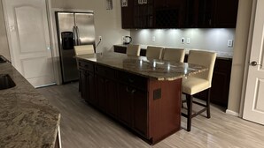 A modern kitchen with a central island, dark wooden cabinets, stainless steel appliances, and pendant lighting. - Quiet & cozy home, bring the whole family. (Monroe Township)