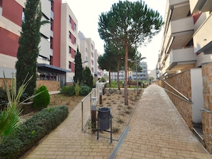 Stylish residential complex with modern architecture, featuring a mix of red and white facades and balconies.