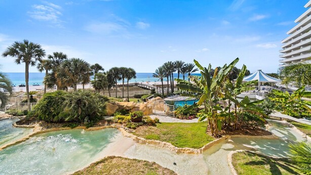 A resort with a pool, palm trees, and a beach view. - Eden East 101 (Pensacola)