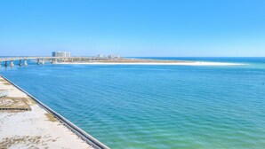 Eine Küstenbrücke mit Strand und Gebäuden im Hintergrund.