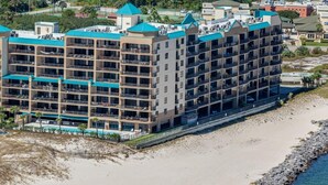 Ein mehrstöckiges Hotel mit Balkonen in Strandnähe.